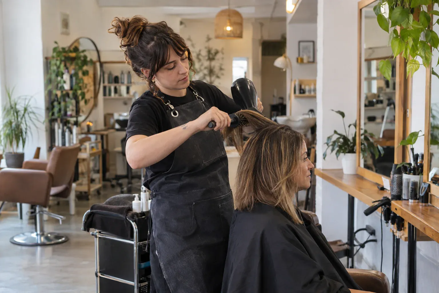 Profesional atendiendo a una clienta en una peluquería con reservas organizadas